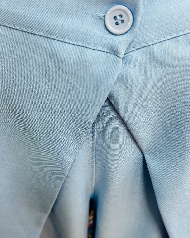 Pantalón fluido azul cielo de tiro alto con diseño cruzado delantero.
